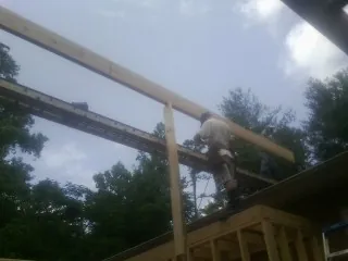 Carpenter setting a ridge beam over a new addition frame in Groveport