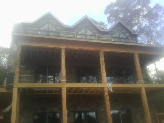 Dormers and porch framing on a large log home under construction — Roof Coating work by our crew in Groveport