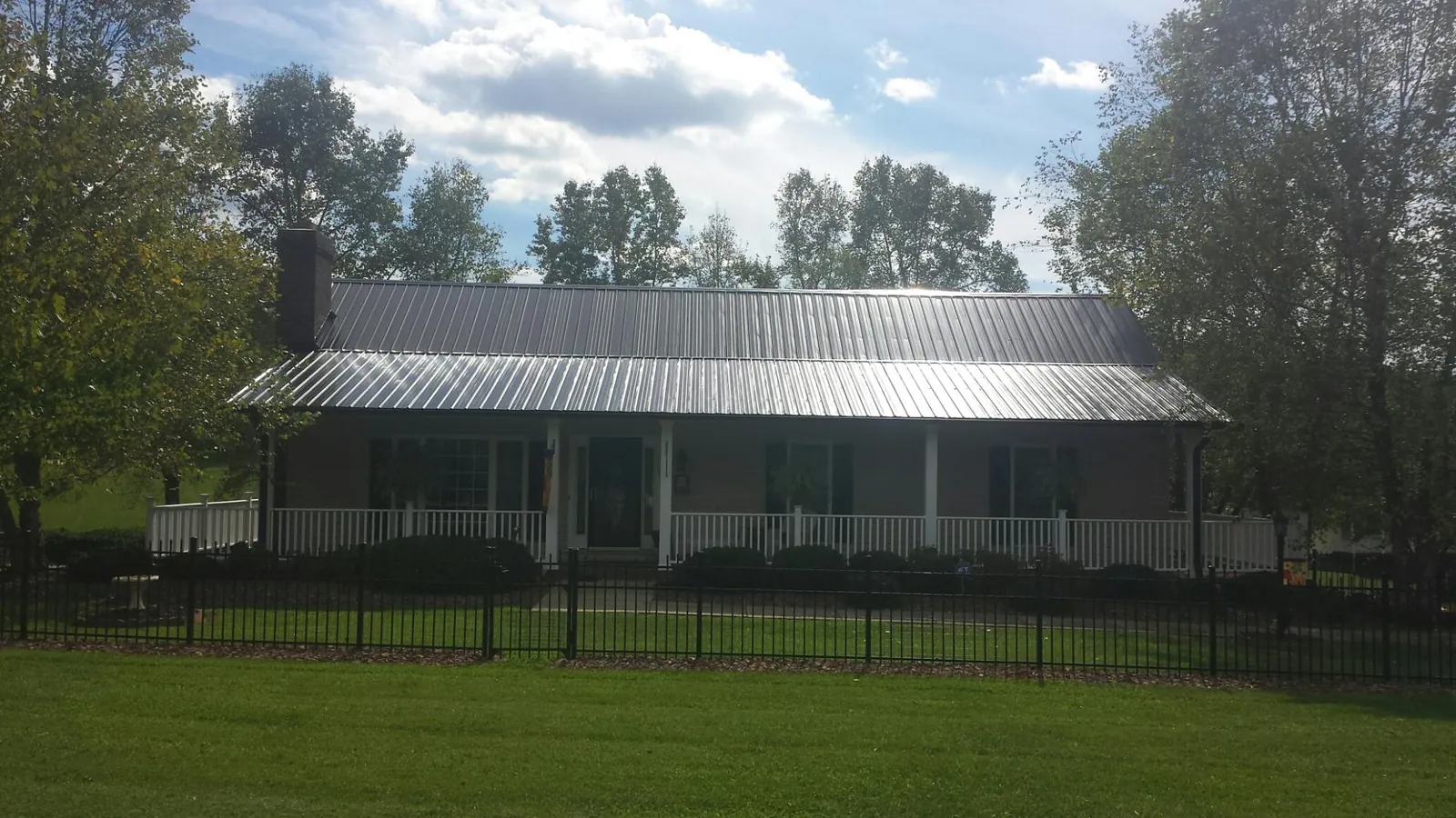 Gray metal roof on a brick ranch with a full width front porch — Gutter Guard Installation work by our crew in Groveport
