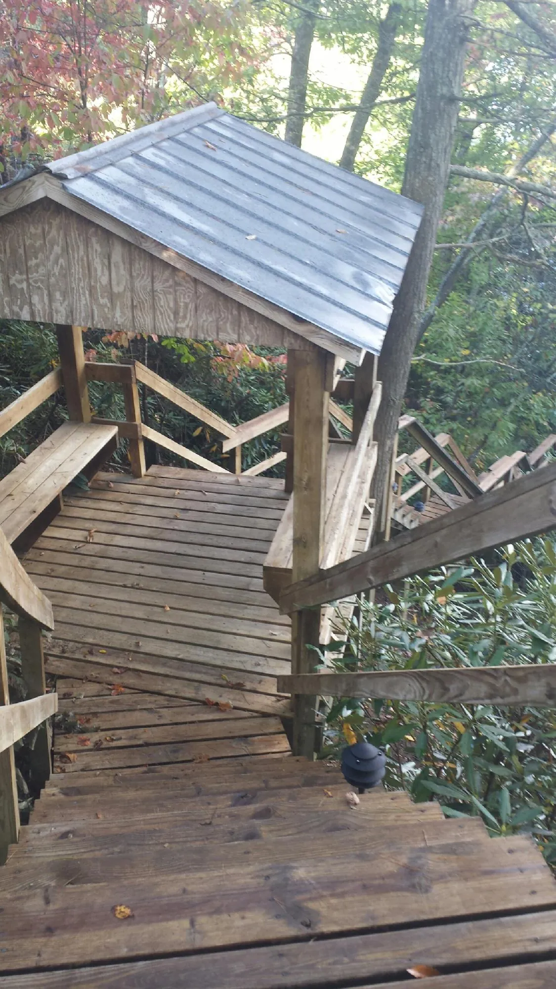 Metal roofed shelter over wooden steps on a wooded walkway — Skylight Repair & Installation work by our crew in Groveport