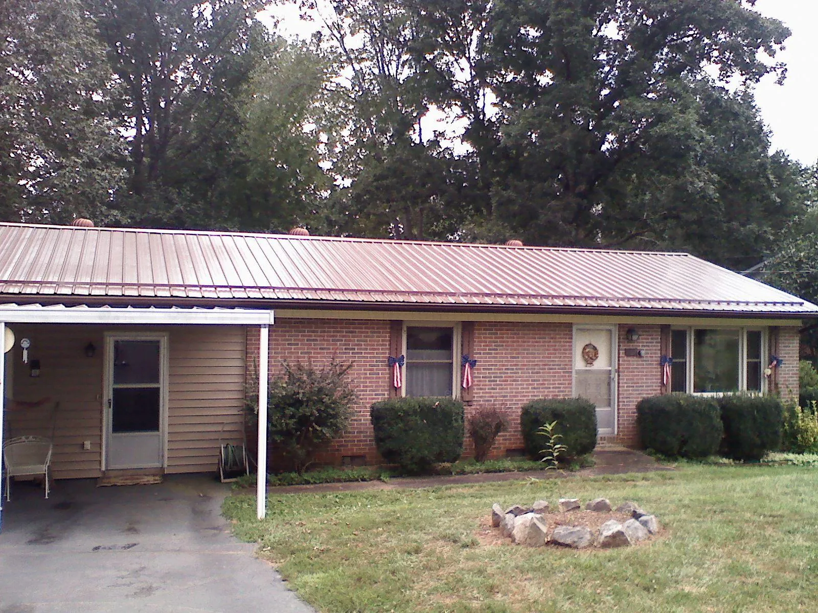 Bronze metal roof and carport on a brick ranch home — Roof Repair work by our crew in Groveport